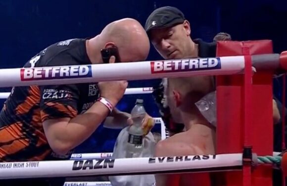 Boxing trainer spotted speaking on the phone while treating fighter mid-bout