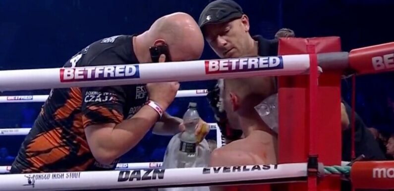 Boxing trainer spotted speaking on the phone while treating fighter mid-bout